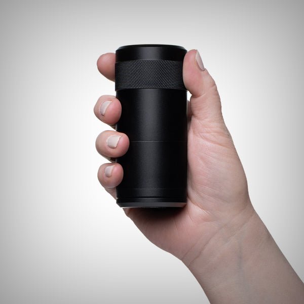 Black MJ Arsenal Capsule grinder and dugout held in hand for size reference