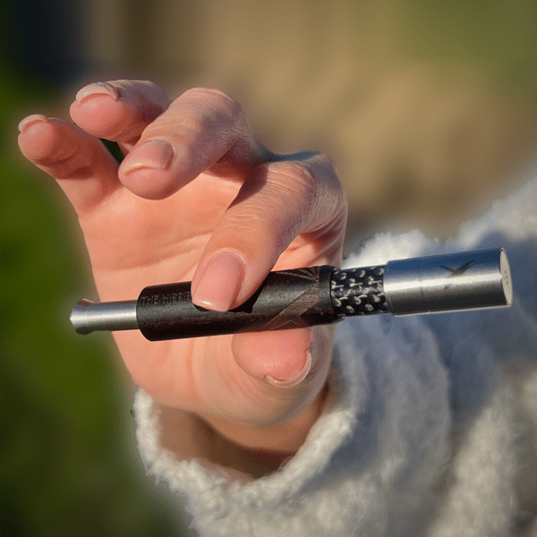 Black Pipe X with telescopic chamber extended while held in hand
