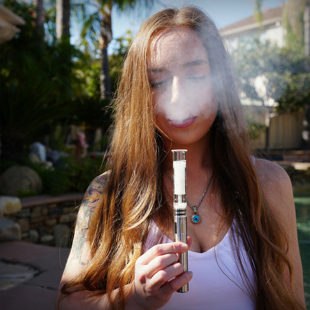 Cipher NOVA electric smoking pipe with clear bubbler attachment in use outdoors