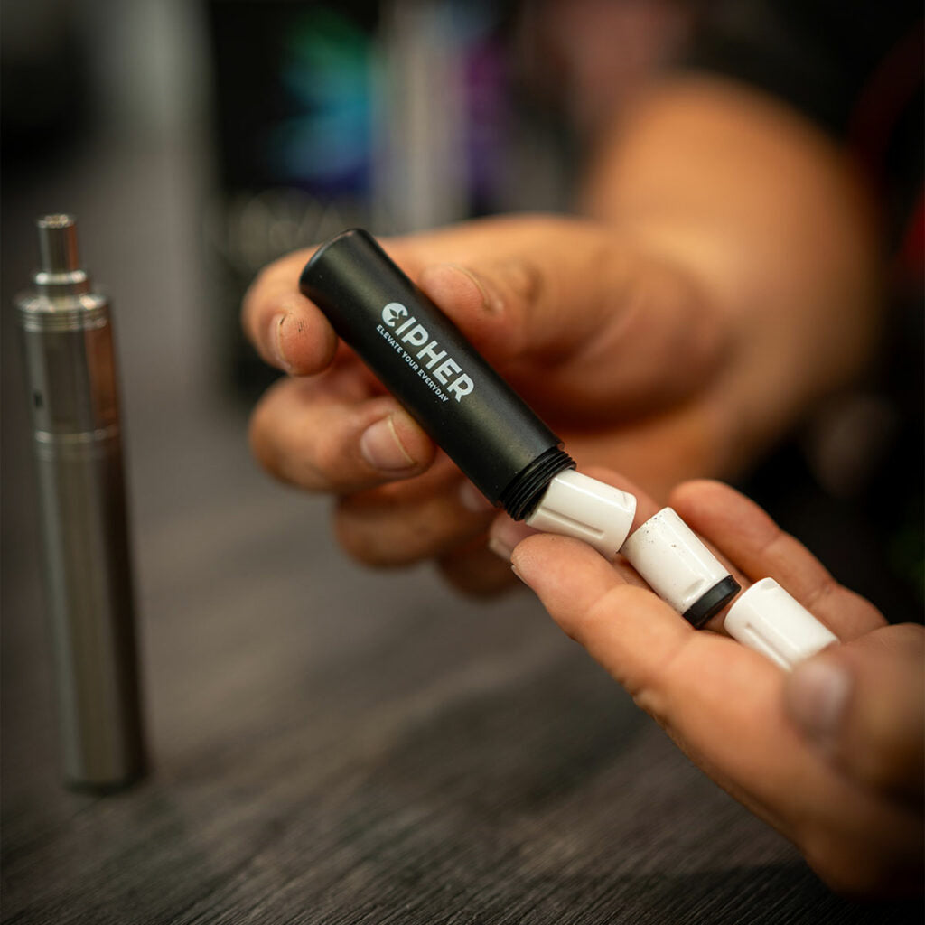 Cipher NOVA pod container with ceramic pods and Stainless Steel NOVA V3 in background