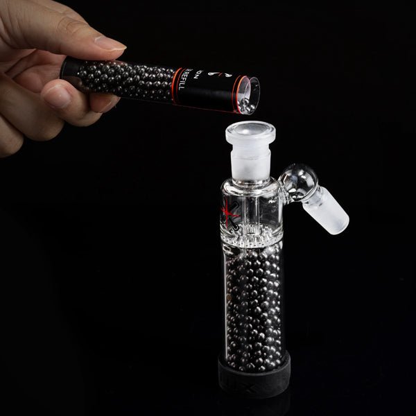 Hand holding Tar Cutter activated carbon bead refill above Pike Reusable Filter