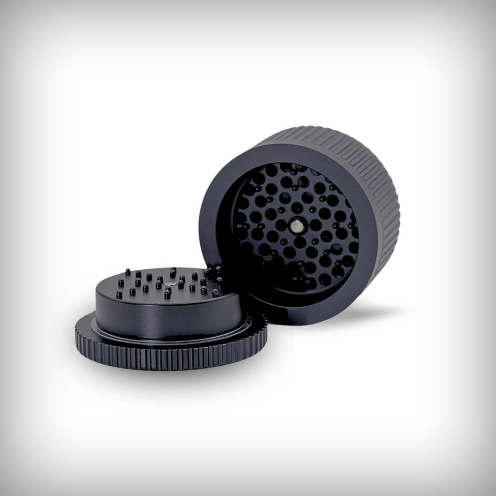 Open Stache Grynder 360 black grinder showing the grinding teeth and lid