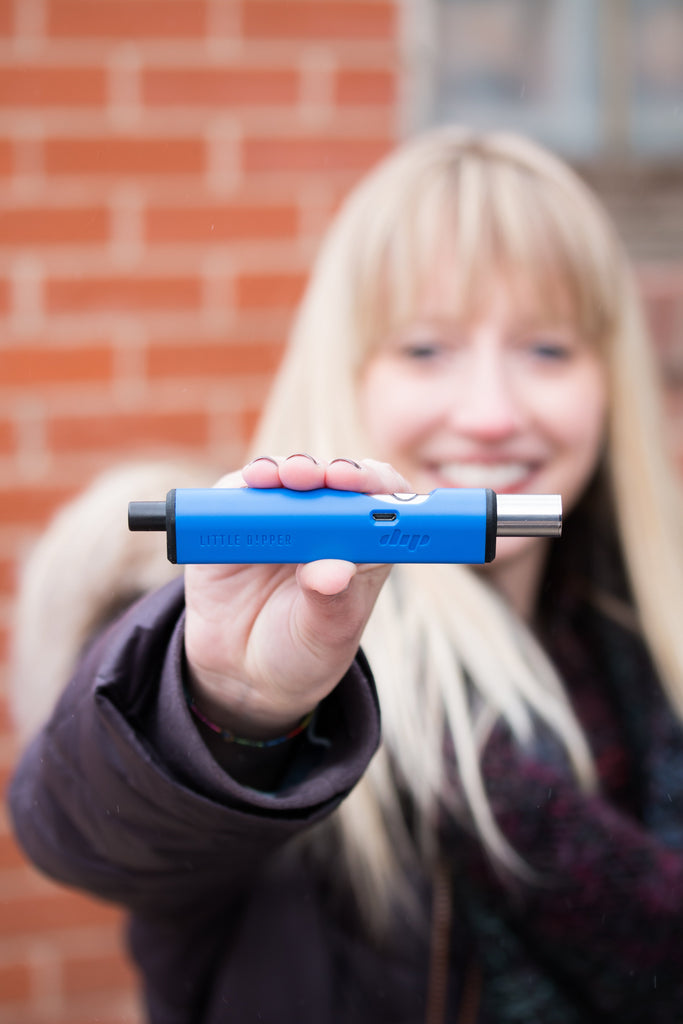 Person holding blue Dip Devices Little Dipper electric nectar collector outdoors