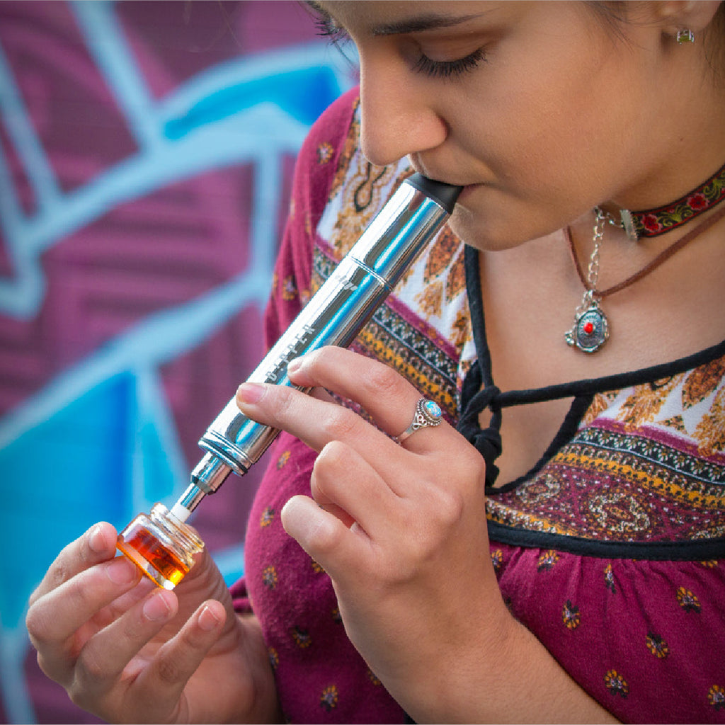 Rainbow Dip Devices Dipper portable vaporizer shown in use women smoking weed