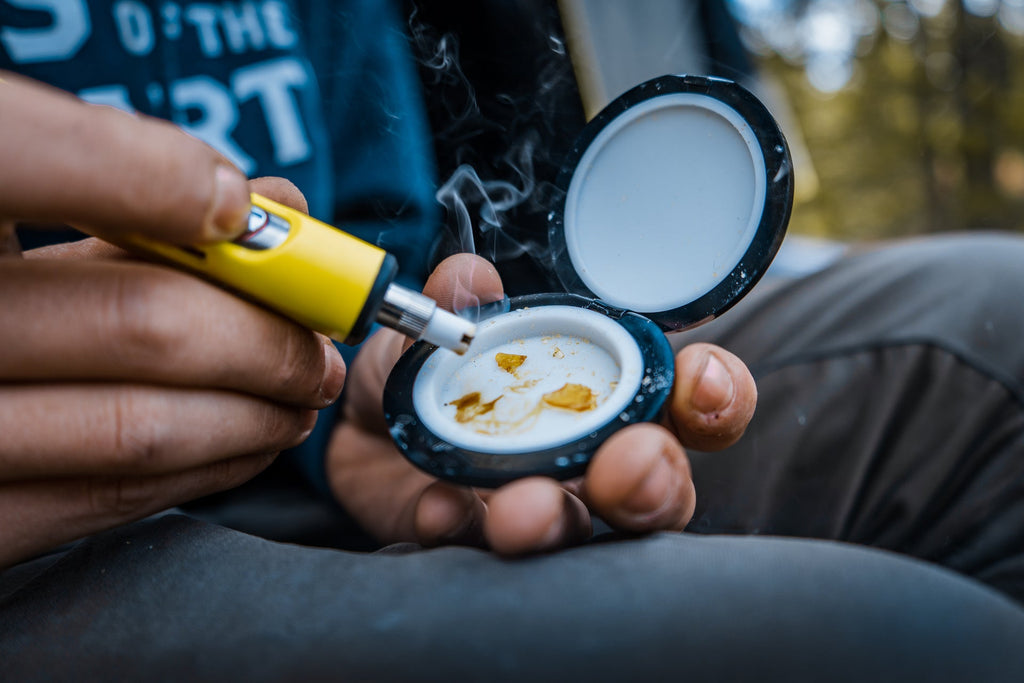 Yellow Dip Devices Little Dipper held above open containers outdoors